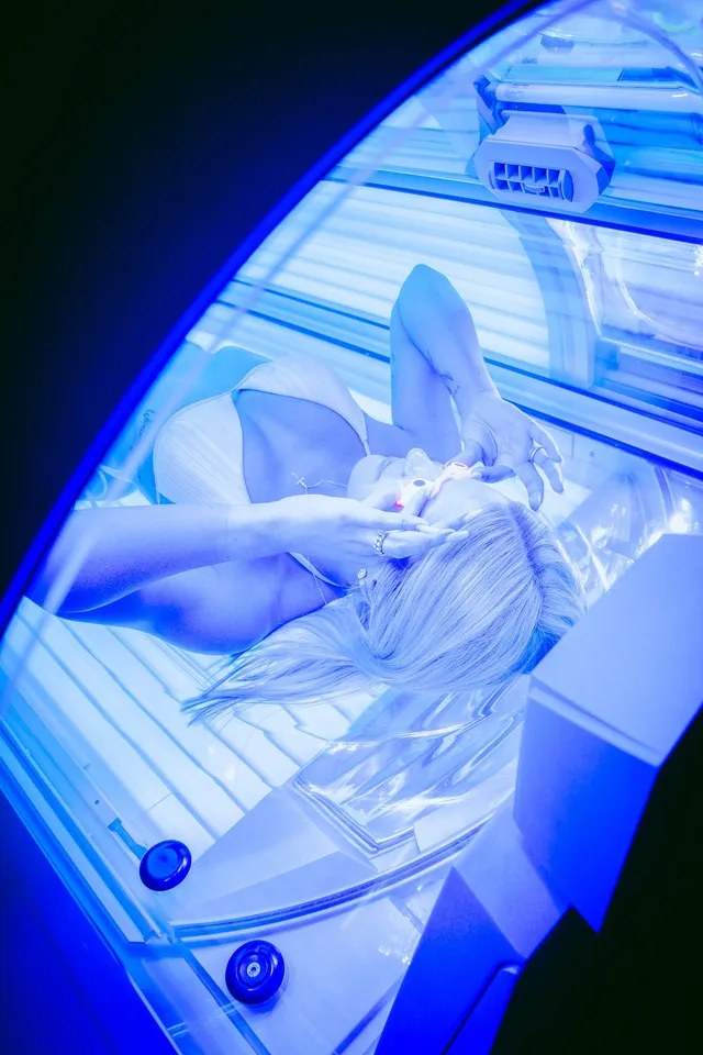 Kundin im Solarium, blau beleuchtet